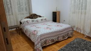 Un dormitorio con una cama con una manta. en Vaikiki Apartman LM, en Novi Pazar