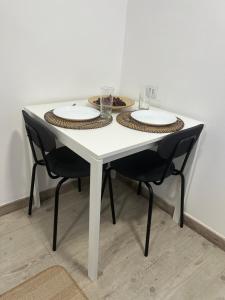 uma mesa branca com duas cadeiras e pratos em Perfect Studio Mouraria em Lisboa