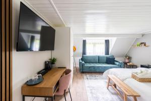 1 dormitorio con 1 cama y 1 sofá azul en Penzion Mezi buky en Chřibská