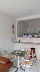 - une table et des chaises dans une cuisine avec un comptoir dans l'établissement Apartamento aconchegante 2 quartos com suíte na praia de Guaibim, à Guaibim