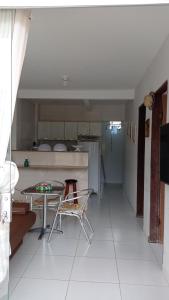 a living room with a table and a kitchen at Apartamento aconchegante 2 quartos com suíte na praia de Guaibim in Guaibim