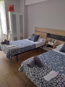 two beds sitting in a room with at Pensión Casa Douro in Santiago de Compostela