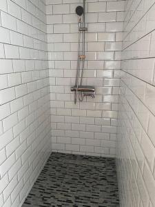 eine weiß geflieste Dusche mit einem schwarz-weißen Fliesenboden in der Unterkunft Spacious app/Antwerp city center #003 in Antwerpen