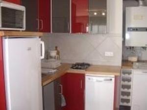 uma cozinha com armários vermelhos e um frigorífico branco em Appartement Palavas-les-Flots, 2 pièces, 6 personnes - FR-1-559-18 em Palavas-les-Flots