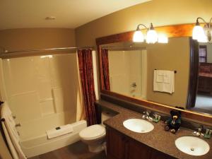 a bathroom with a sink and a toilet and a mirror at Trappers Landing #27 By Bear Country in Sun Peaks