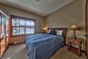 un dormitorio con un osito de peluche sentado en una cama en Trappers Landing #27 By Bear Country, en Sun Peaks