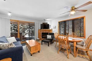a living room with a couch and a table and chairs at Snow Creek Village #37 By Bear Country in Sun Peaks