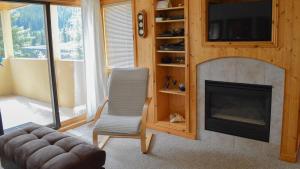 a living room with a chair and a fireplace at Snow Creek Village #49 in Sun Peaks