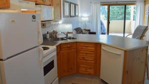 a kitchen with a white refrigerator and a sink at Snow Creek Village #49 in Sun Peaks