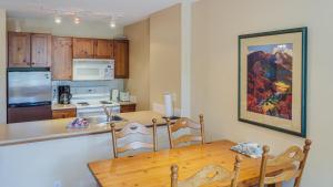 a kitchen with a wooden table and a dining room at Fireside Lodge #419 By Bear Country in Sun Peaks