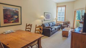 a living room with a couch and a table at Fireside Lodge #419 By Bear Country in Sun Peaks