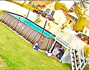 een huis met een zwembad naast een huis bij luxurious home spacious yard & above ground pool in Shirley