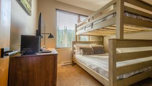 a bedroom with a bunk bed and a desk with a computer at Echo Landing #05 by Bear Country in Sun Peaks +20 photos