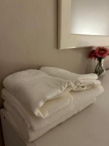 una pila de toallas blancas sentadas en un mostrador bajo un espejo en Aromas de Azahar en Bella Vista
