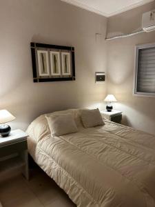 1 dormitorio con 1 cama grande, 2 mesas y 2 lámparas en Aromas de Azahar en Bella Vista