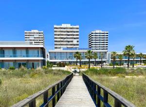 a wooden boardwalk leads to the beach and buildings at Alvor Seven 10 in Alvor