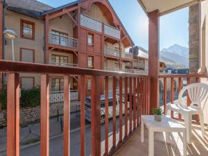 ein Balkon eines Gebäudes mit einem Tisch und einem Stuhl in der Unterkunft Appartement 6 pers. Saint Lary - Centre, Garage, WiFi - FR-1-296-361 in Saint-Lary-Soulan