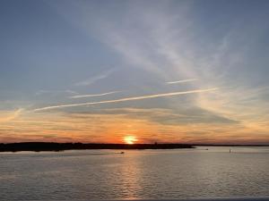 einen Sonnenuntergang über einem großen Wasserkörper in der Unterkunft Harbour Island 402L home in Ocean City