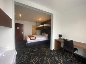 a hotel room with a bed and a desk and a bedroom at Duck Inn Mt Buller in Mount Buller