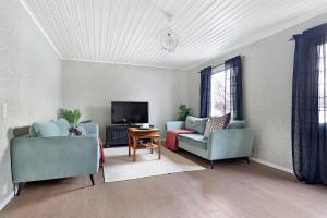 a living room with two couches and a tv at Guestly Homes - 3BR Seaside Luxury Villa in Piteå