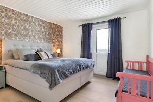 a bedroom with a large bed and a window at Guestly Homes - 3BR Seaside Luxury Villa in Piteå
