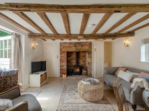 a living room with a couch and a fireplace at Hope Cottage in Ilketshall Saint Andrew