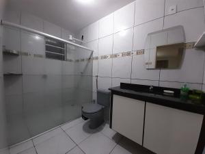 a white bathroom with a toilet and a sink at Flat com garagem para até 5 pessoas in Campina Grande