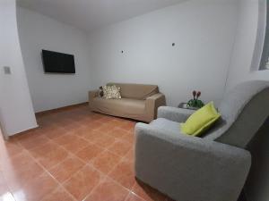 uma sala de estar com duas cadeiras e um sofá em FLAT FAMILIAR com garagem até 5 pessoas em Campina Grande