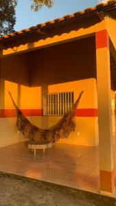 a hammock hanging on the side of a building at Chalés Recanto in Guaraciaba do Norte