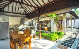 - une cuisine ouverte et un coin repas dans une maison avec une table en bois dans l'établissement The Haven, à Gili Trawangan