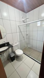 a bathroom with a toilet and a glass shower at Pousada Primavera in Mucugê