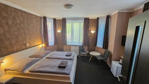 1 dormitorio con 2 camas, mesa y sillas en Almond en Teplice