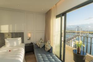 a hotel room with a bed and a balcony at Dana Pearl Bay in Danang