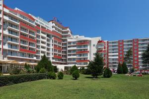 a large apartment building with trees in a park at Hotel Fenix in Sunny Beach