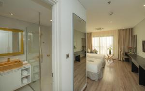 a bathroom with a shower and a bed and a sink at Dana Pearl Bay in Danang