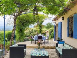 a patio with a table and chairs under a pergola at Charming Villa in Villes-sur-Auzon with Swimming Pool in Villes-sur-Auzon