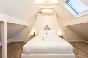 ein Schlafzimmer mit einem weißen Bett im Dachgeschoss in der Unterkunft Renovated Terrace-Style Apartment in Woollahra in Sydney
