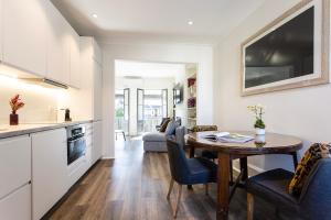 eine Küche und ein Wohnzimmer mit einem Tisch und Stühlen in der Unterkunft Renovated Terrace-Style Apartment in Woollahra in Sydney
