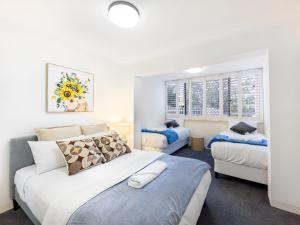 a bedroom with two beds and two windows at Spacious Newly Furnished 2bed Apartment in South Brisbane in Brisbane