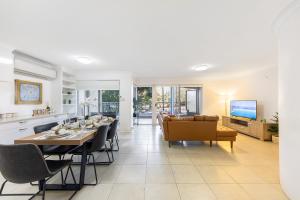 a dining room and living room with a table and chairs at Spacious Newly Furnished 2bed Apartment in South Brisbane in Brisbane