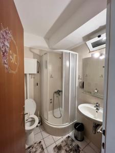y baño con ducha, aseo y lavamanos. en Residence Bella en Stari Grad
