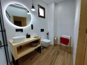 a bathroom with a sink and a mirror and a toilet at Apartamento Ricardo in Carnota