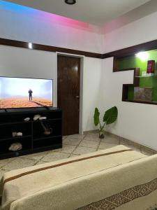 sala de estar con TV de pantalla plana en la pared en Quinta La Milagrosa en José C. Paz