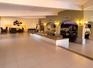 a lobby with a large room with tables and chairs at Posada Real Los Cabos in San José del Cabo