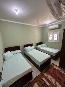 1 dormitorio con 2 camas y ventana en Skylen Apartment 2 en Hurghada
