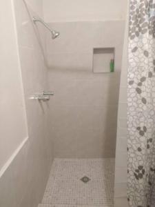 ein weißes Bad mit einer Dusche und Fliesenboden in der Unterkunft Apartamento zona hotelera #6 planta alta in Mexicali + 2 Fotos