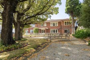 a house with a bench and trees in front of it at Graham Apartments in Hobart