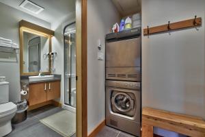 a bathroom with a washer and dryer in a house at Kookaburra Lodge #202 By Bear Country in Sun Peaks