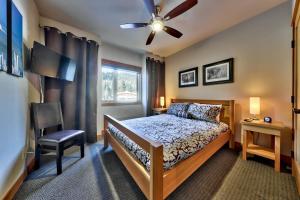 a bedroom with a bed and a ceiling fan at Kookaburra Lodge #202 By Bear Country in Sun Peaks