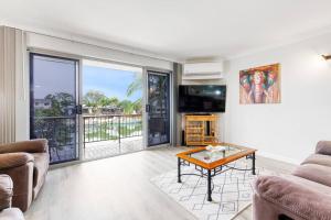 a living room with a couch and a table at La Costa Vista, Mooloolaba in Mooloolaba
